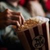 A hand grabbing a piece of popcorn